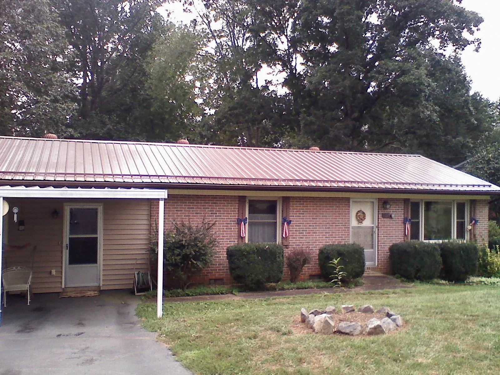 Bronze metal roof and carport on a brick ranch home — Roof Repair work by our crew in Fall Branch